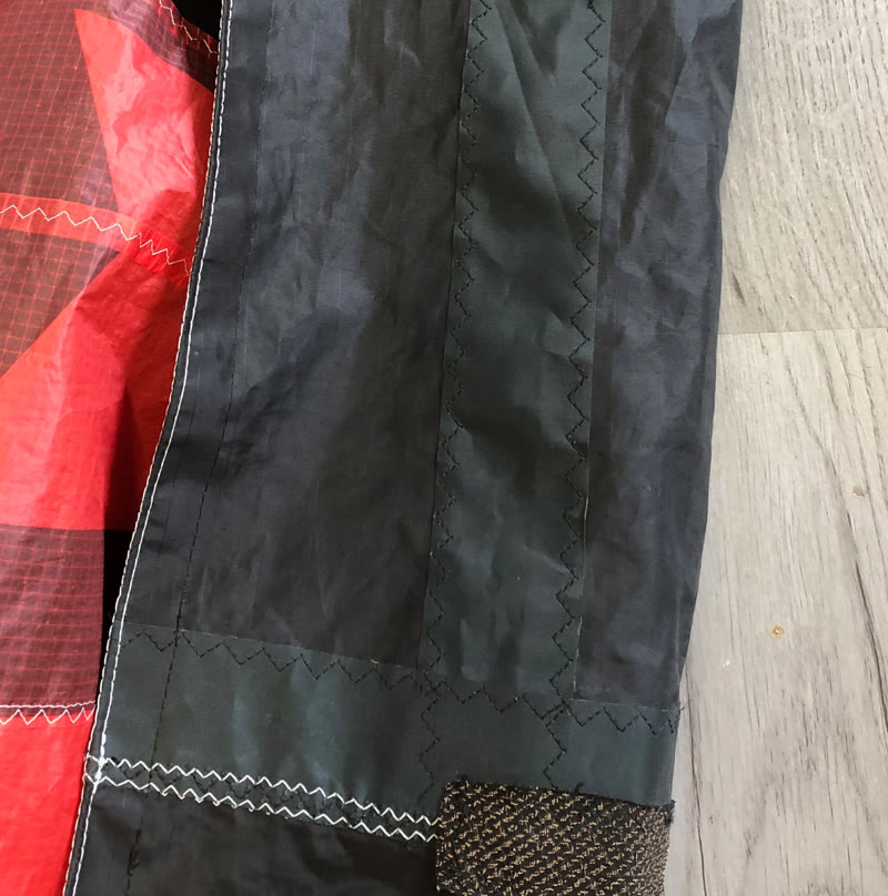 Reparierte Naht an einem schwarz-roten Kite